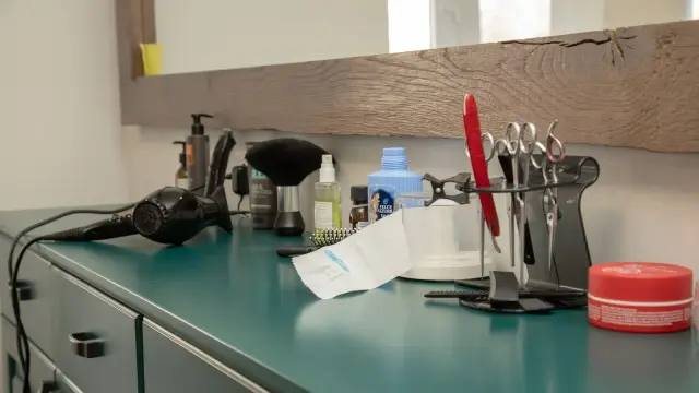 Asciugacapelli appoggiato sul ripiano di un bagno accanto allo specchio