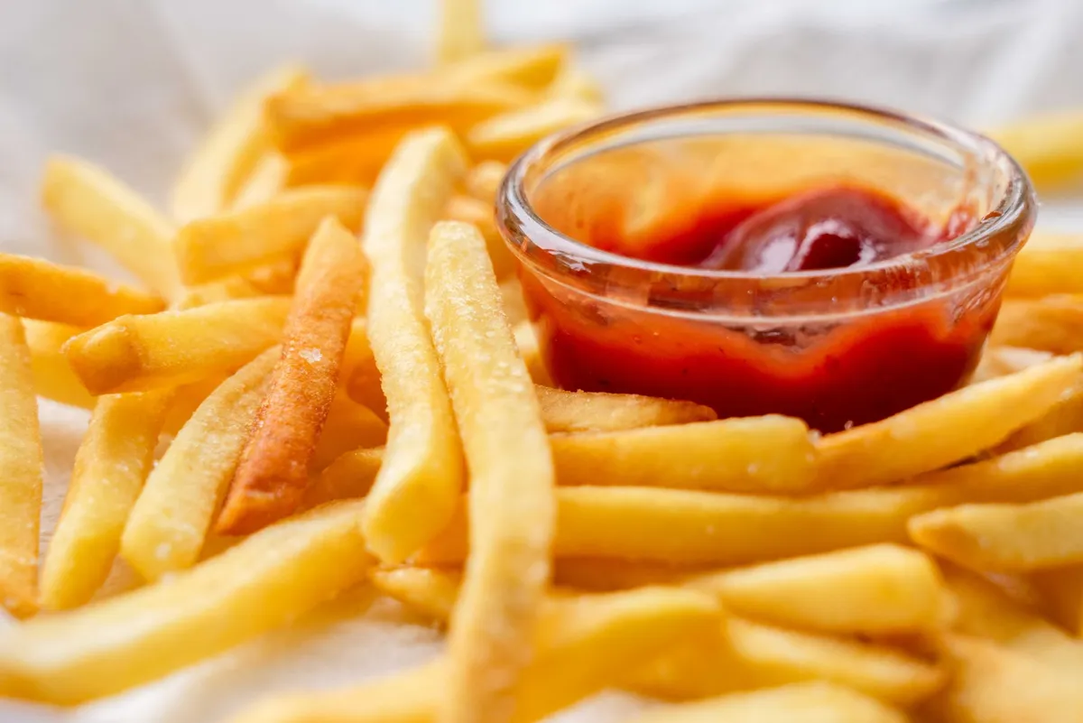 Freshly cooked fries in an air fryer basket