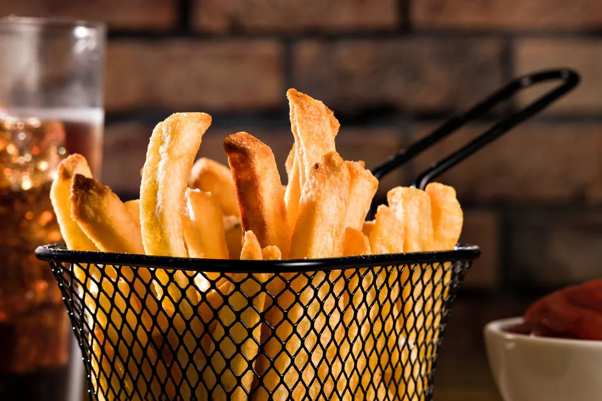 Patatas recién hechas en la cesta de una freidora de aire
