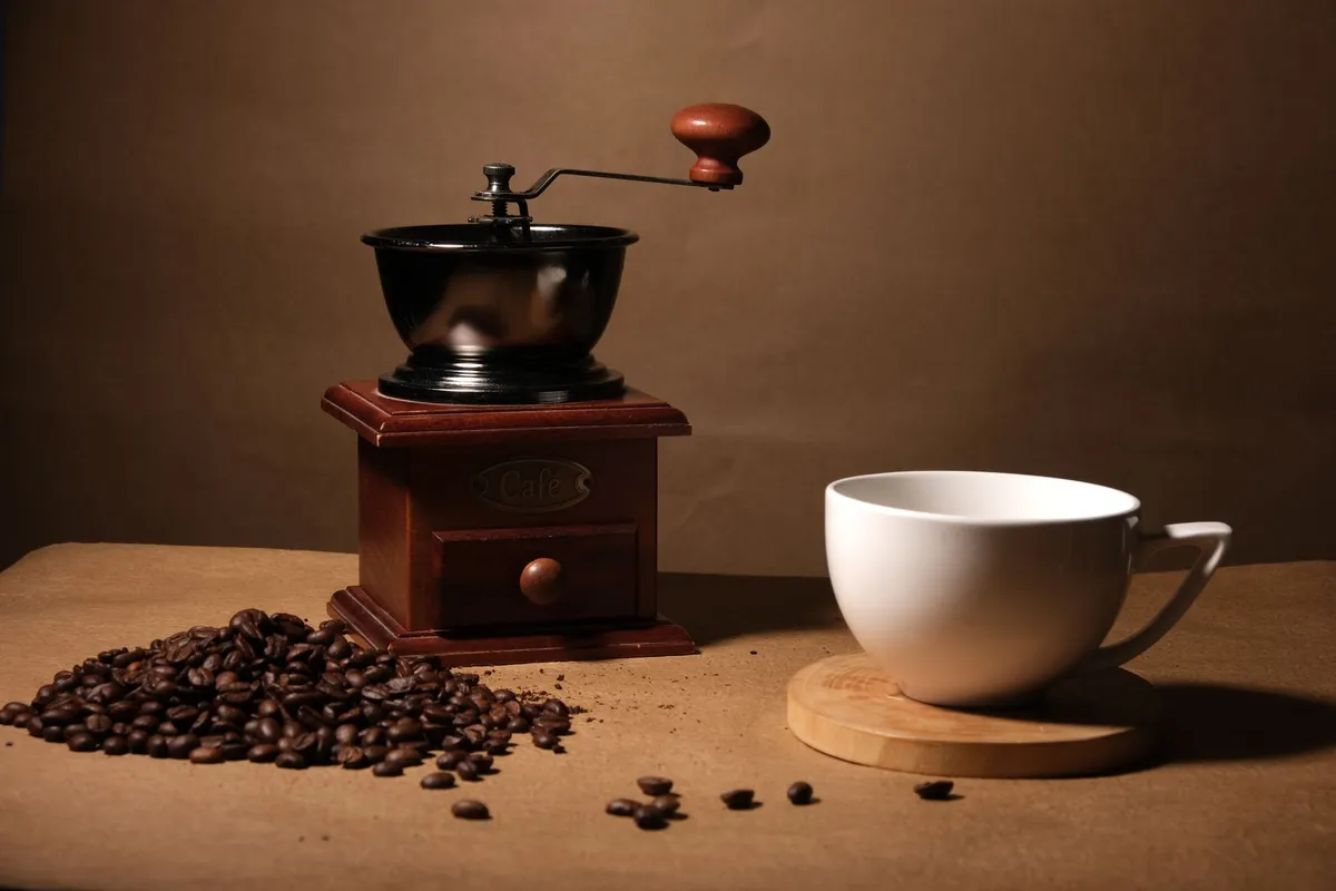 Coffee beans beside a grinder