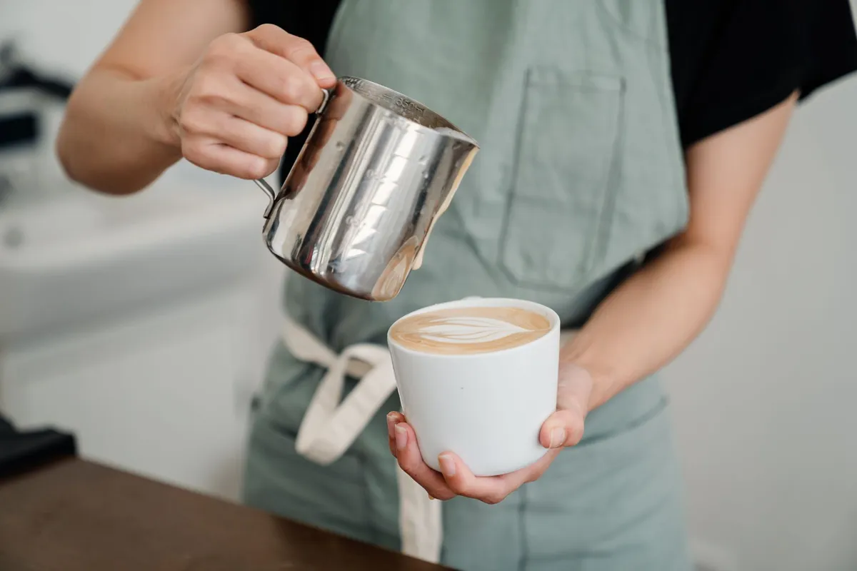 Leche espumada servida en una taza de cappuccino