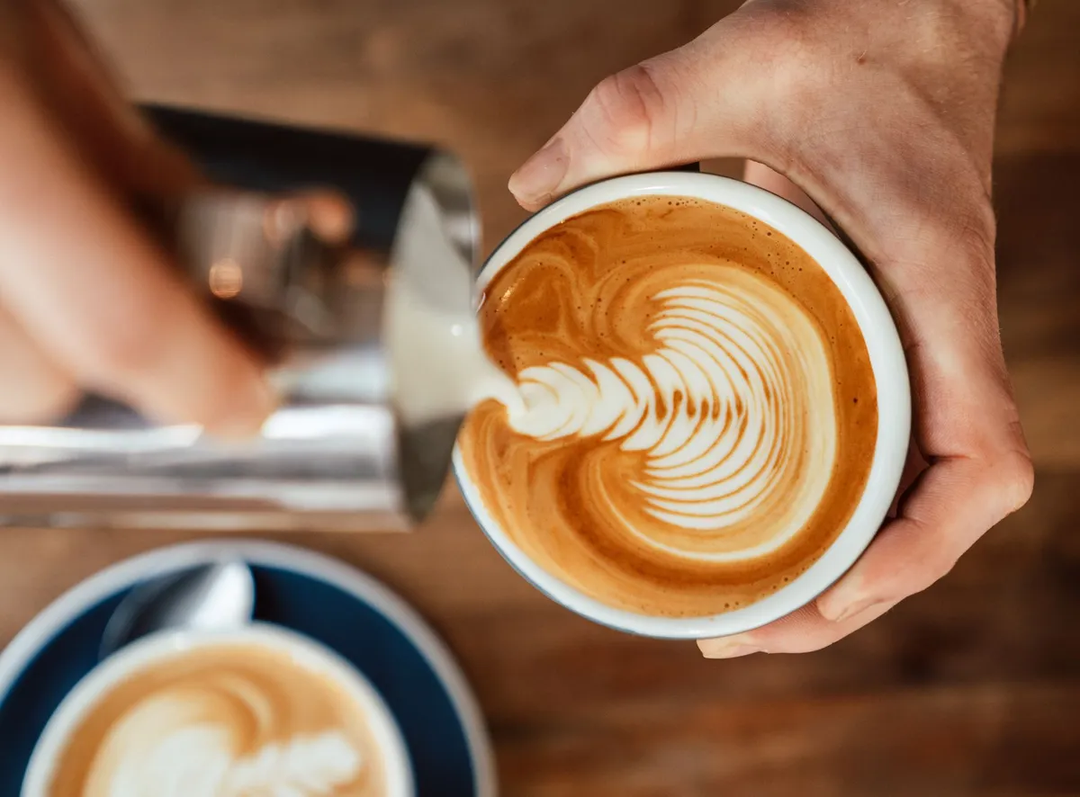 Latte montato versato in una tazza da cappuccino