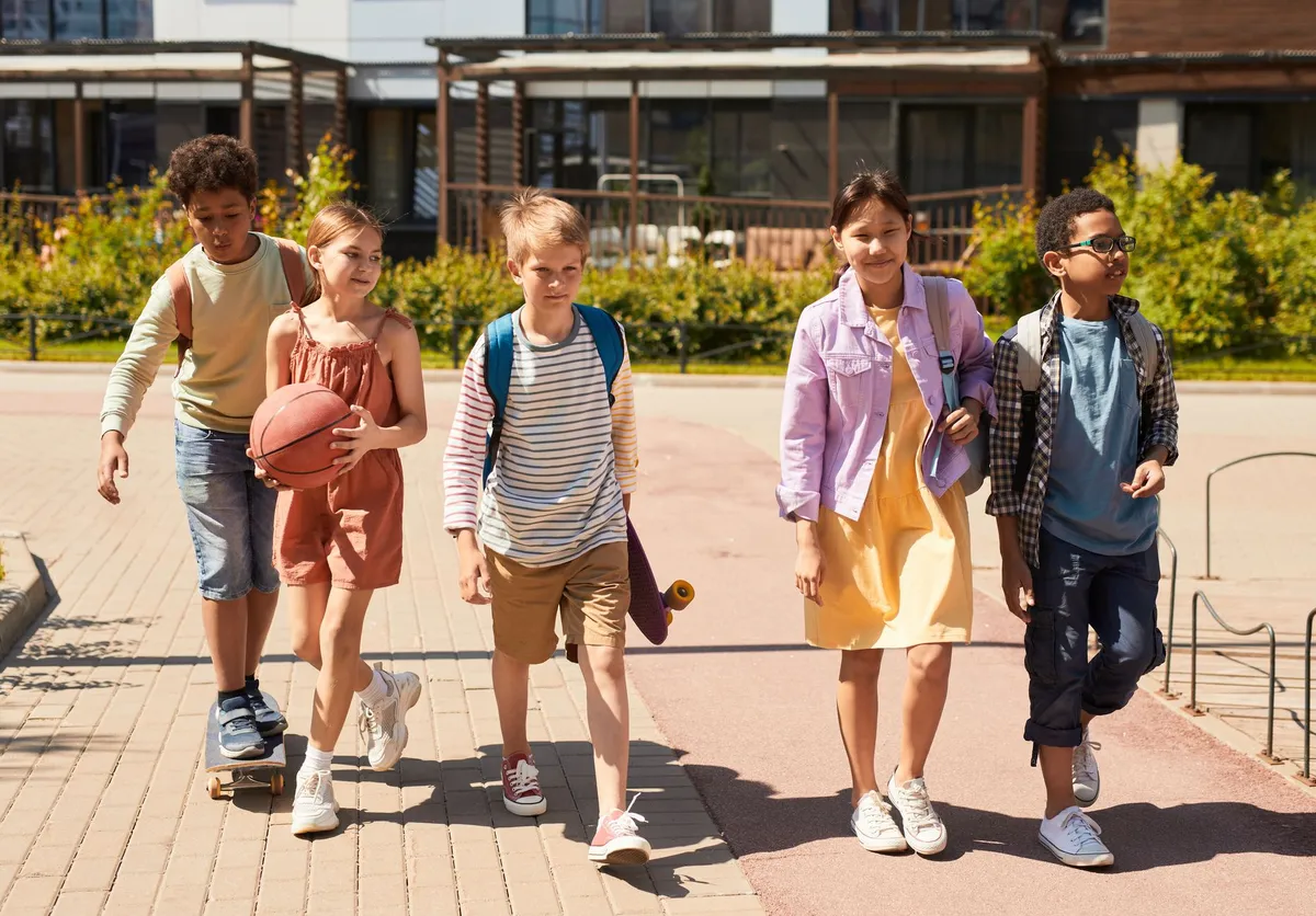 Bambini che vanno a scuola con lo zaino in spalla