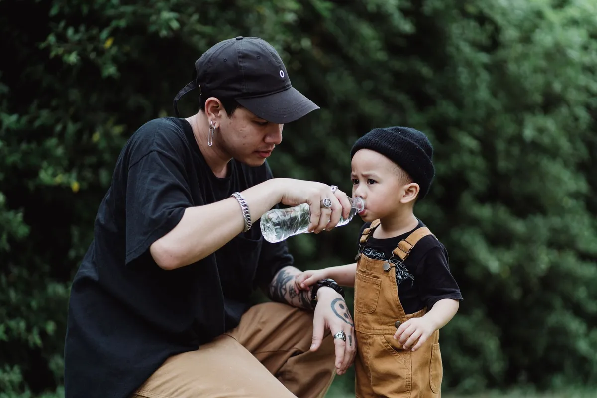 Niño bebiendo de una botella con pajita