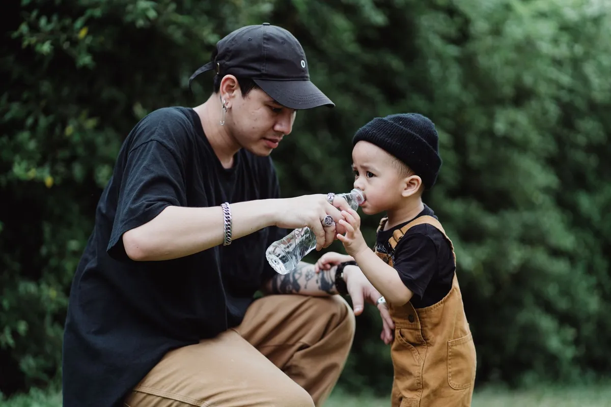 Bambino che beve da una borraccia con cannuccia