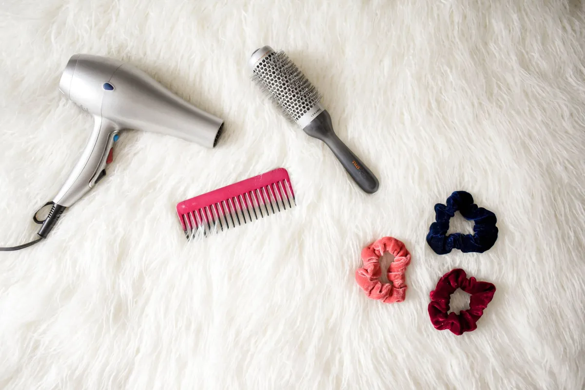 Piastra per capelli e spazzola su un ripiano del bagno