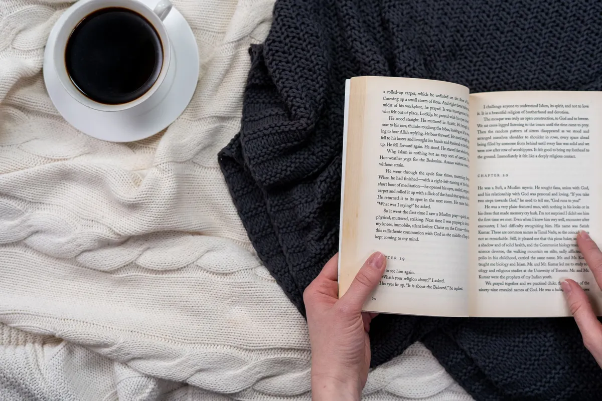 Person reading under a blanket in a cold room